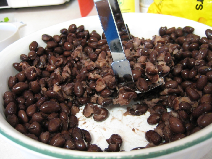 mashing black beans